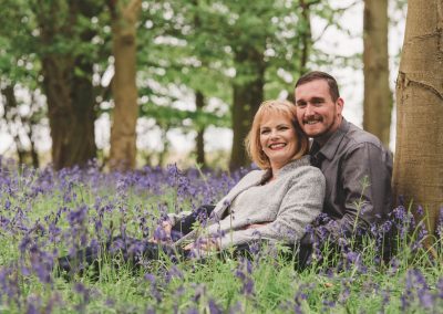 Slice of Life Photography - Engagement photography, couple sitting against a tree in the bluebell woodlands, Lincolnshire wedding photographer